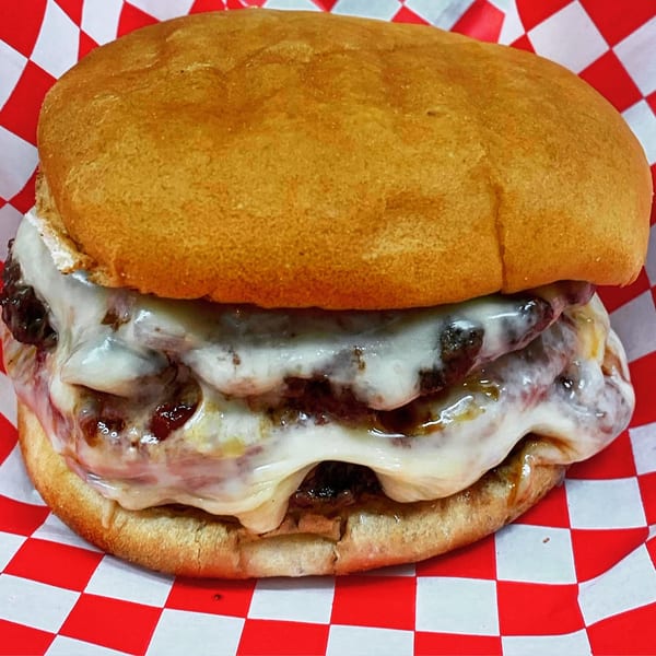 A double patty burger from The Burger Bunker, loaded with melted cheese and caramelized onions.